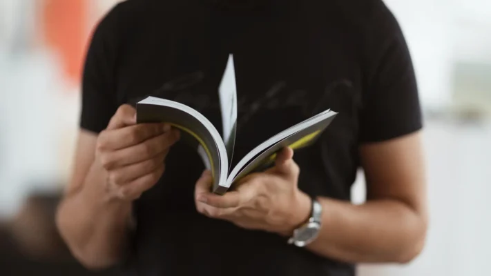 Produtor de eventos folheando guia de eventos corporativos na mão