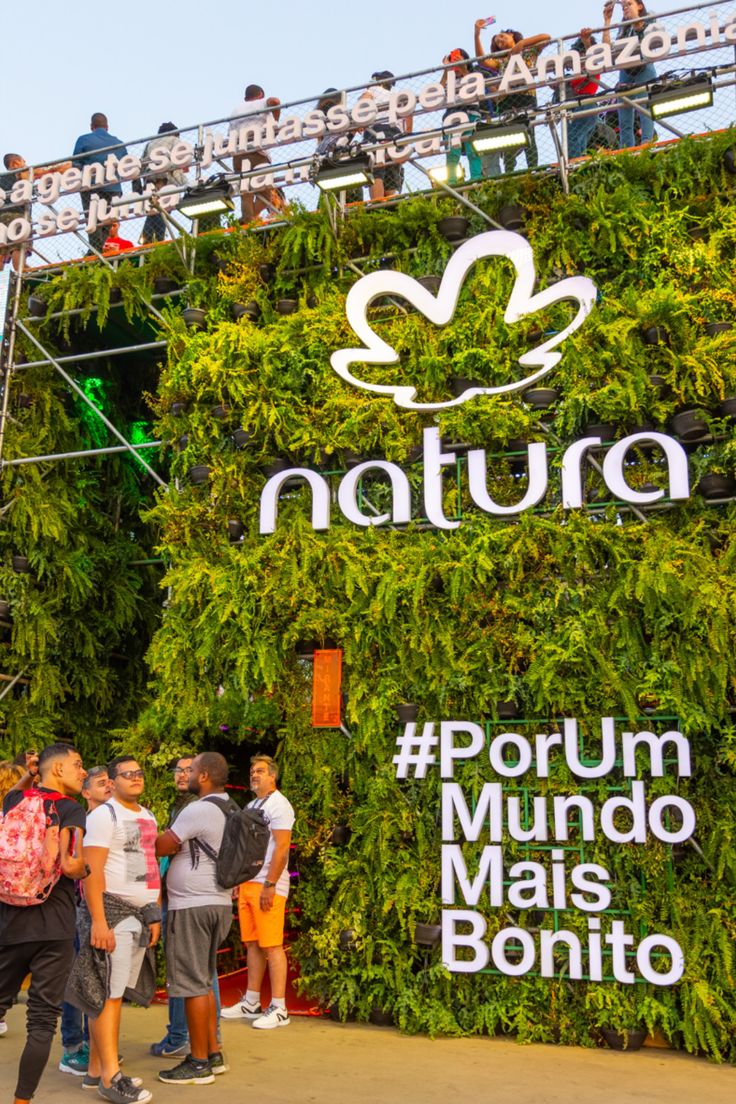 Painel verde da Natura em evento, com dizeres "por um mundo mais bonito"