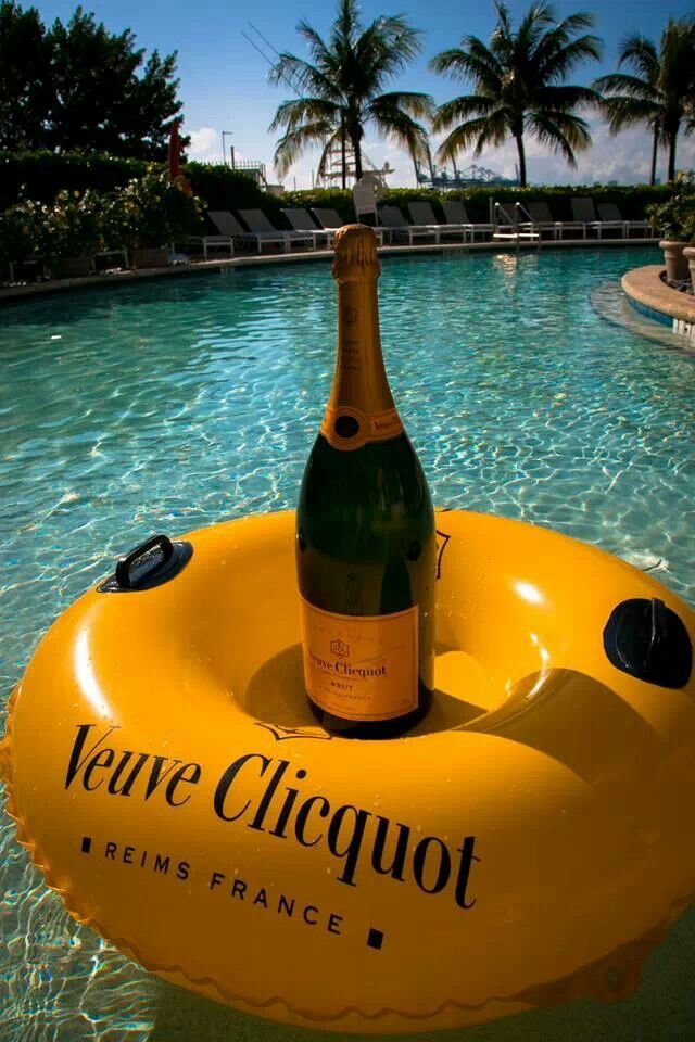 Uma garrafa de Veuve Clicquot em uma boia dentro da piscina em um resort locado para evento corporativo